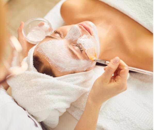 woman laying down, getting a facial applied